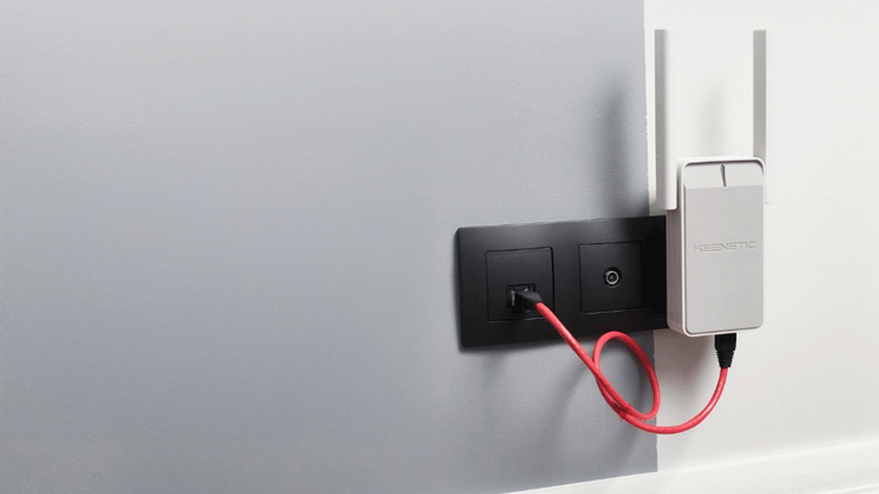 Ретранслятор Keenetic Buddy 6 подключенный к электрической розетке с красным Ethernet-кабелем для расширения Wi-Fi покрытия в доме