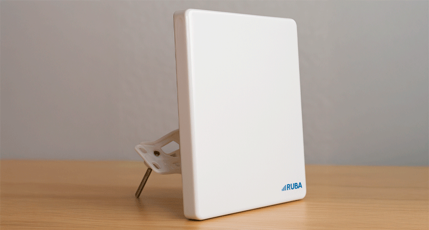 4G LTE антенна Ruba LTE14D30 с креплением, установленная на деревянной поверхности. Белый корпус с логотипом RUBA, предназначена для усиления сигнала интернета