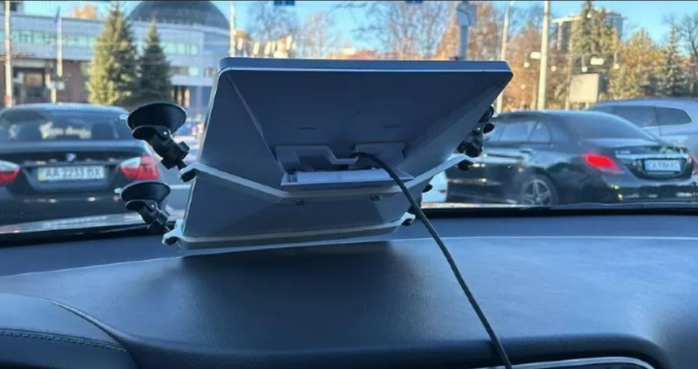 Антенна Starlink Mini, установленная на приборной панели автомобиля с креплением на присосках.