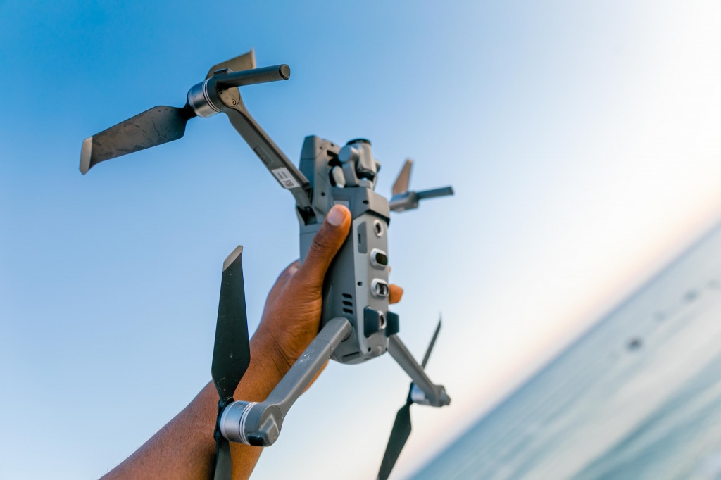 shallow-focus-photo-of-person-holding-gray-quadcopter-drone-2271587.jpg